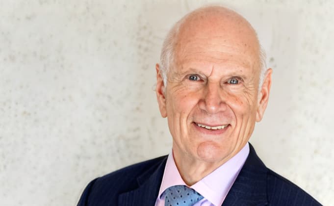 Photo of smiling man in blue suit with pink shirt