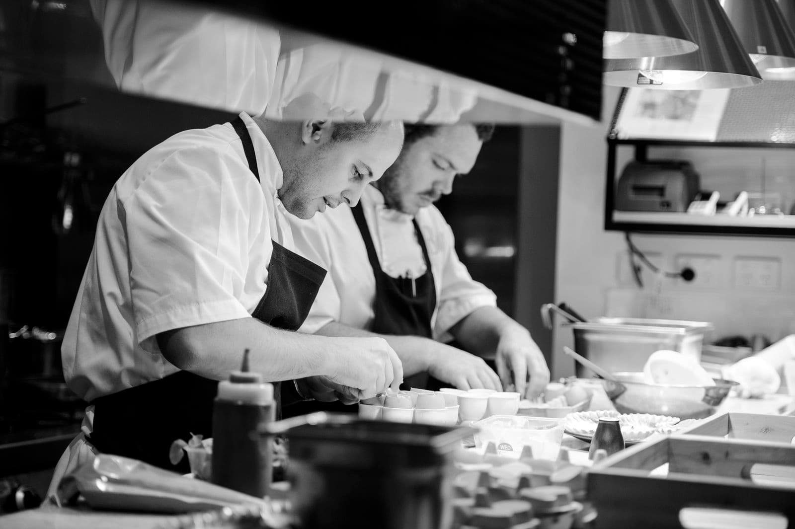 Two chefs in a kitchen preparing food