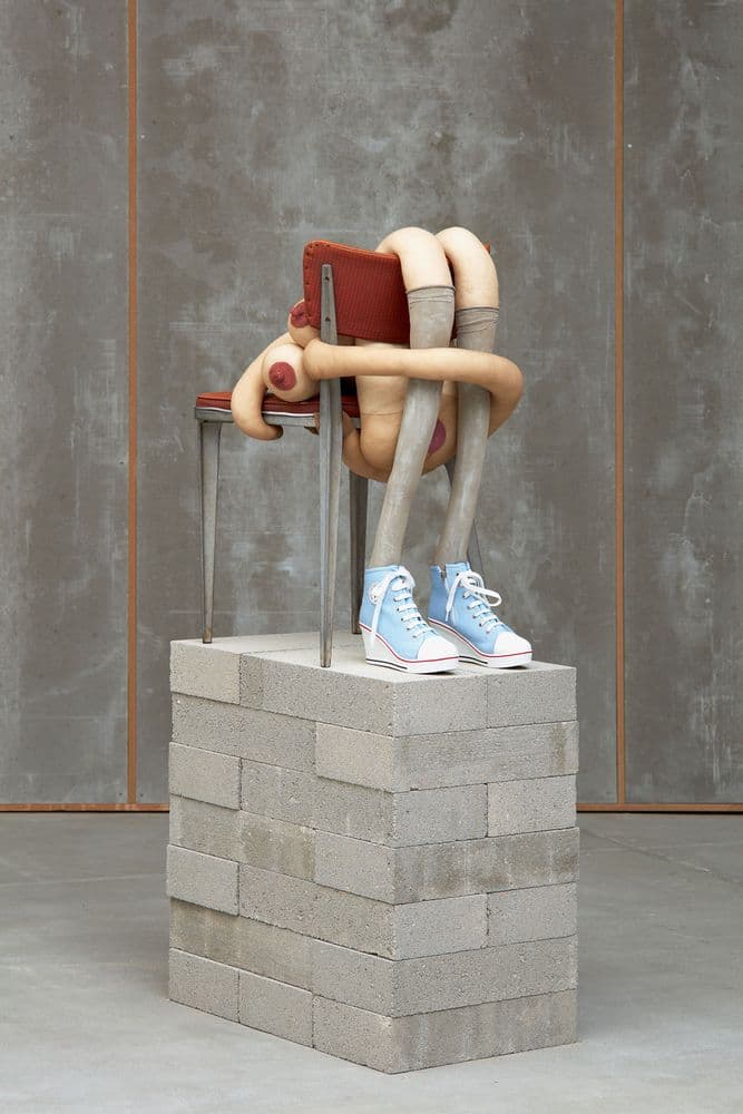 sculpture depicting abstract figure sitting on chair