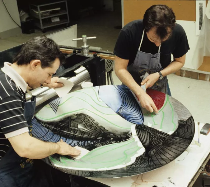 Colour Photo of two men applying coloured ink to shaped magnesium plate