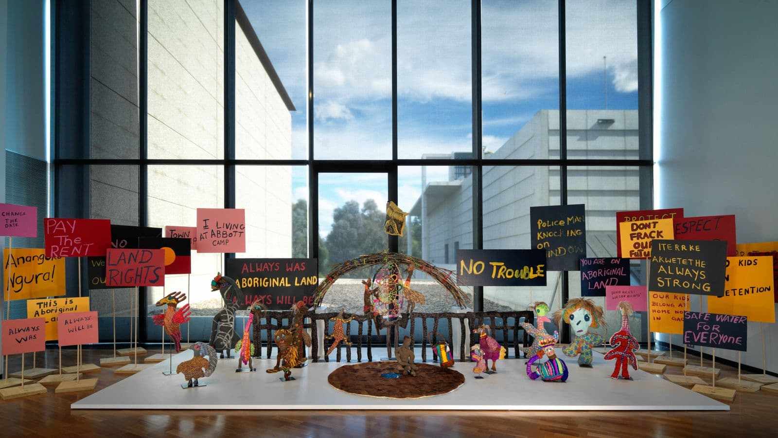 A soft sculpture depiction of Parliament House surrounded by soft sculptures of people and native Australian animals and protest signs