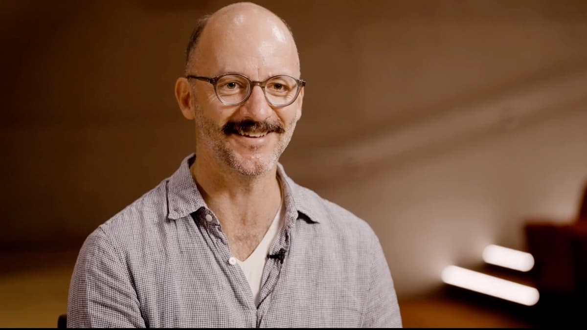 Screenshot from a video close-up shot of a man talking and smiling