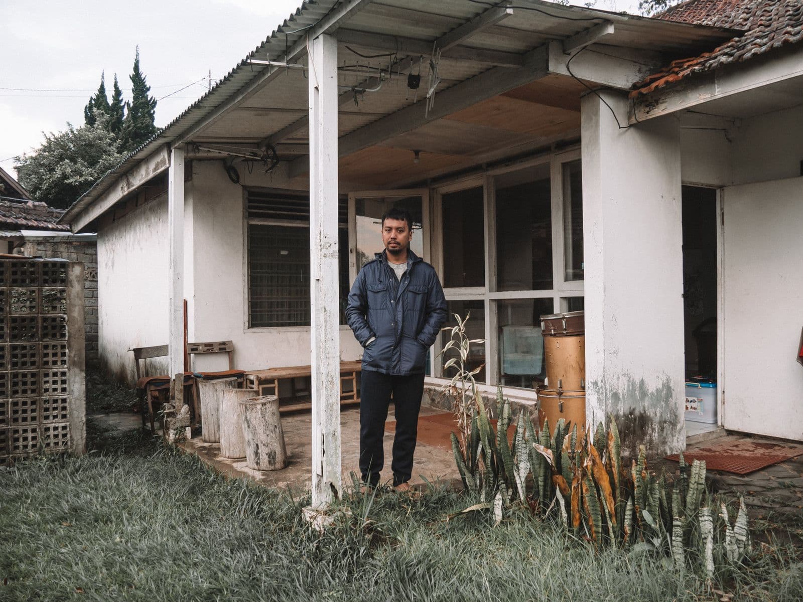 A man stands in front of a house