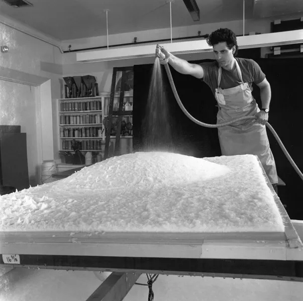 Black and white image of man hosing down protruding area of pulp