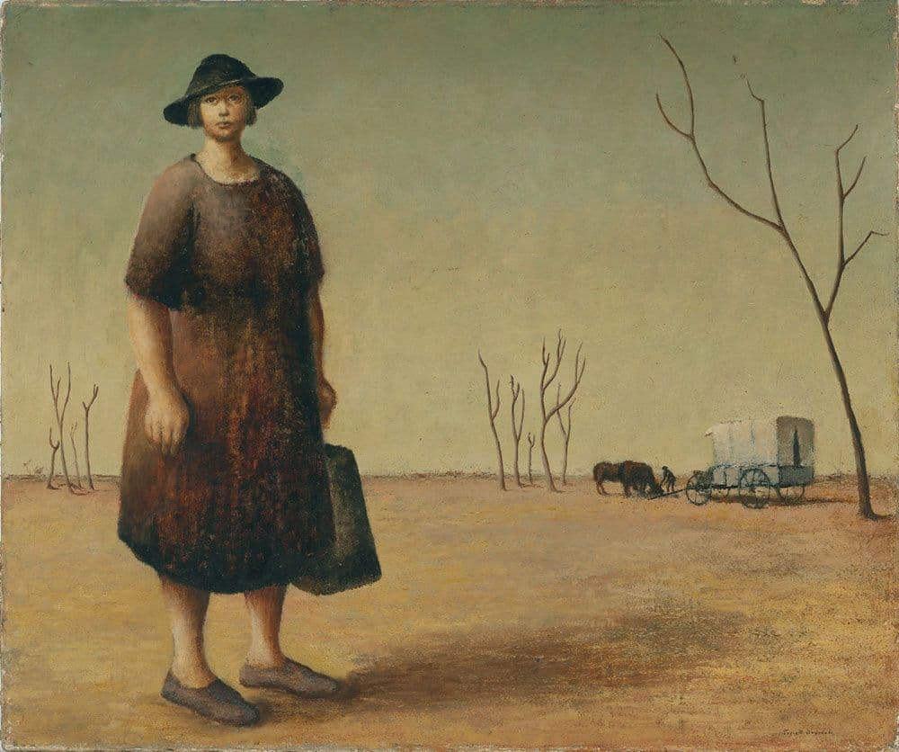 Woman in brown dress and hat standing in arid landscape with horse and wagon in far background