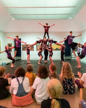 Audience of young people watching a dance troupe performing acrobatics