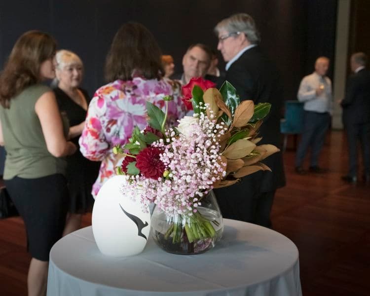 Image of floral bouquet on a table with a lamp with Qantas logo beside it
