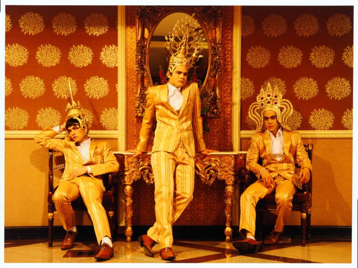 A photograph of three figures in gold