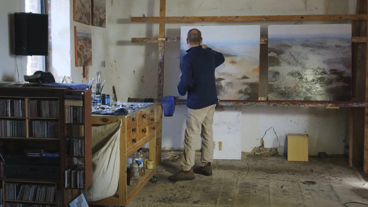 Video still of artist painting in studio