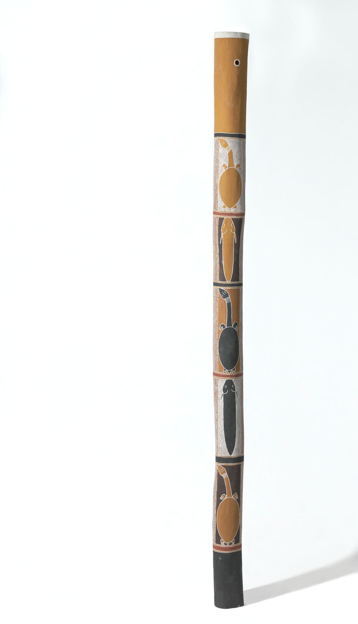 Tall , thin ochre pole with black, yellow and white tortoise, catfish and herringbone
