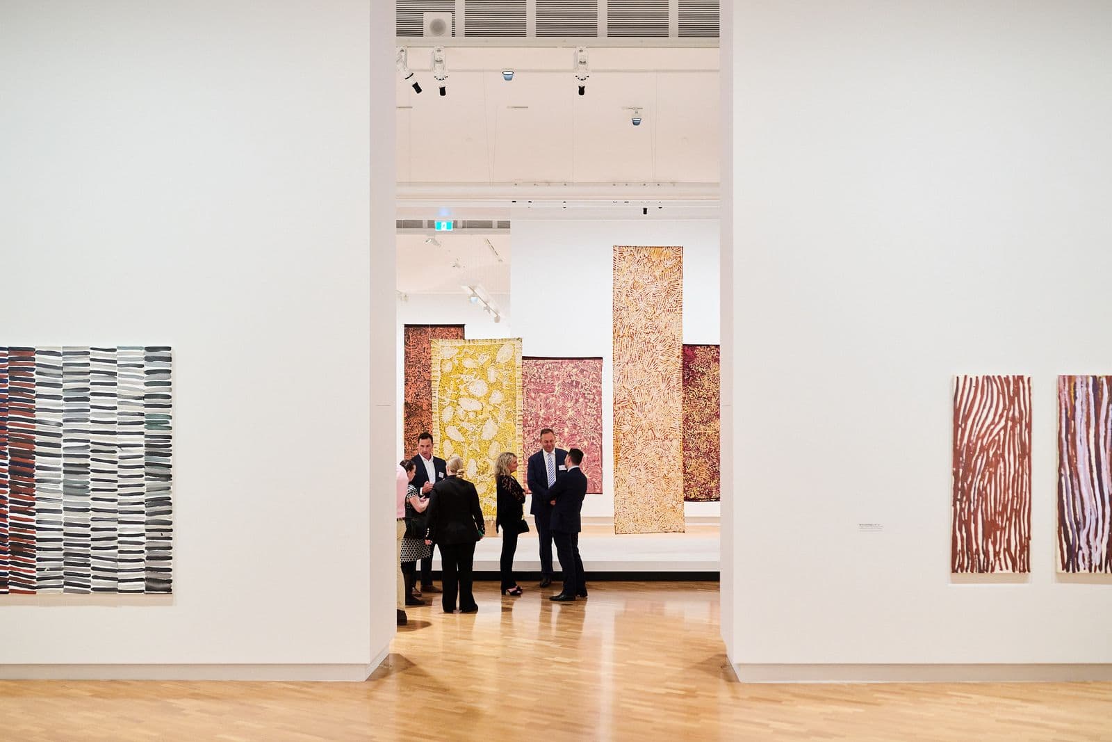 Photo of a group of people talking in a gallery space