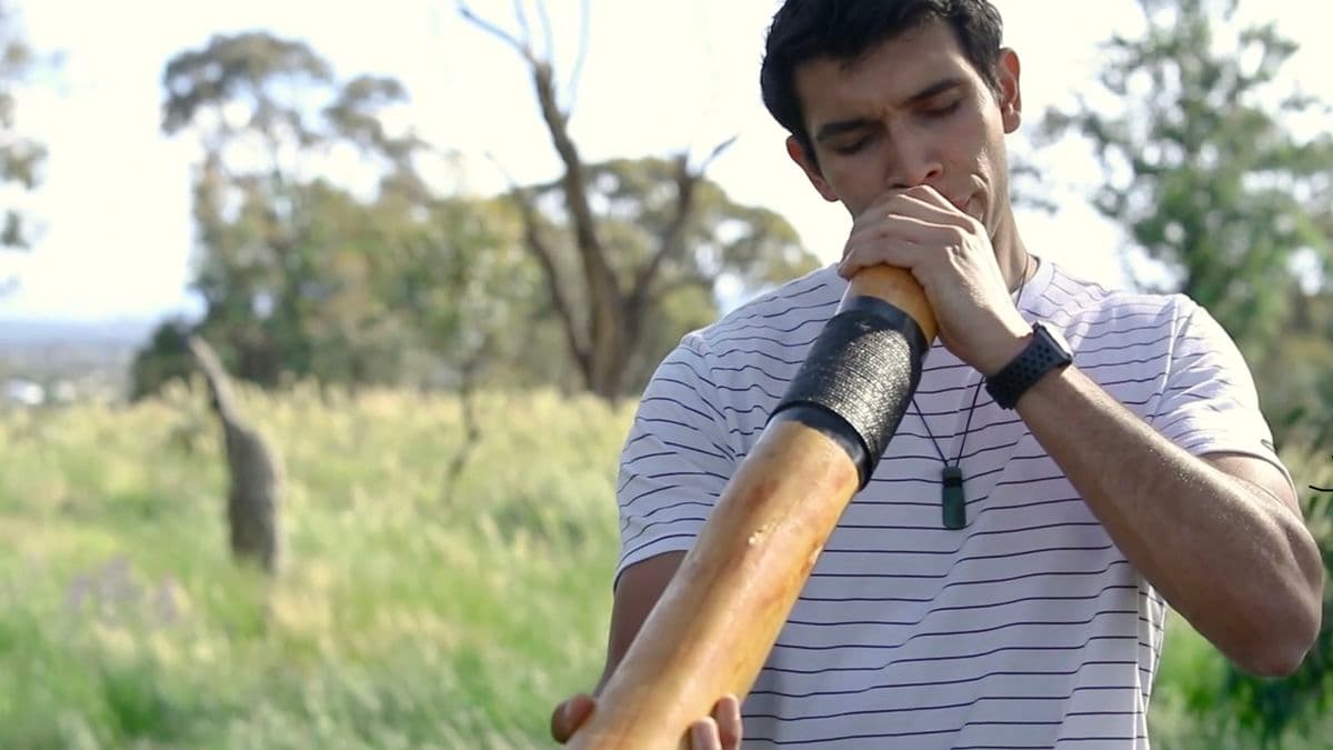 Video still of man playing didgeridoo.