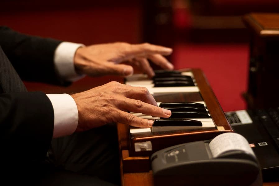 A persons hands playing the piano keys