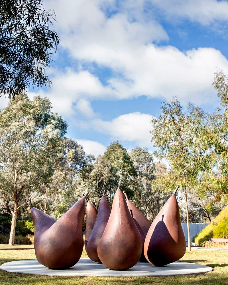 A group of seven brown metal pear sculptures