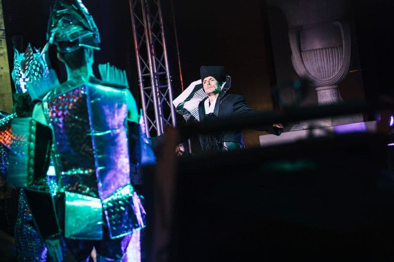 Performance photo of male performer in elaborate black costume