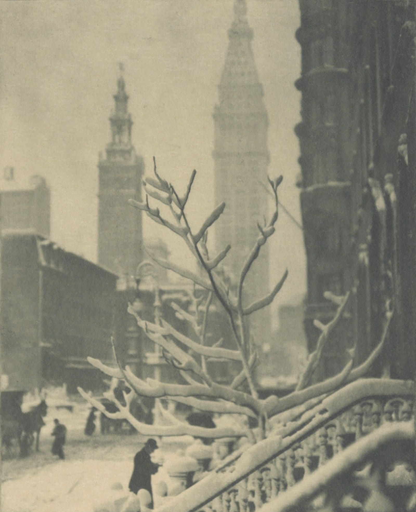 New York street scene with a snow-covered tree and street, and two large building in the background
