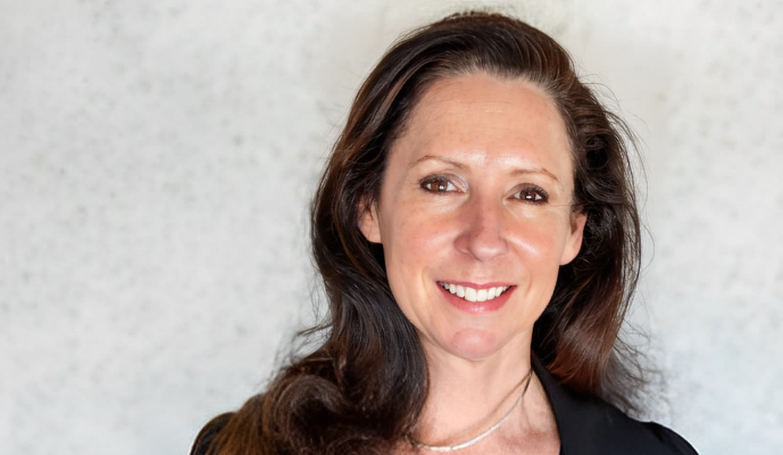 Portrait of a smiling brunette woman in black shirt