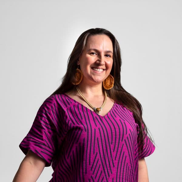 Photographic portrait of a woman standing against a white background.