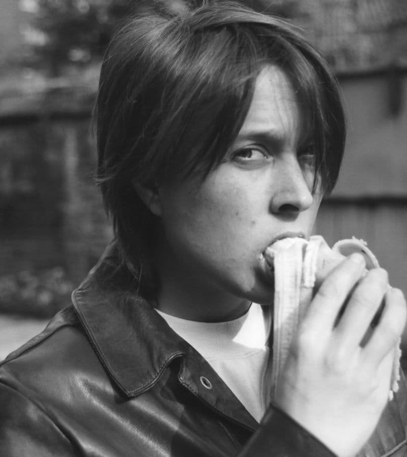 Black and white image of a woman eating a banana