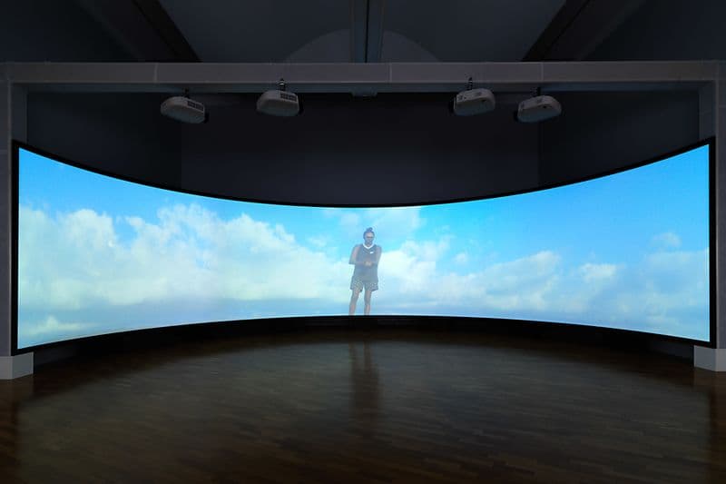 An installation photo of a large screen showing a film