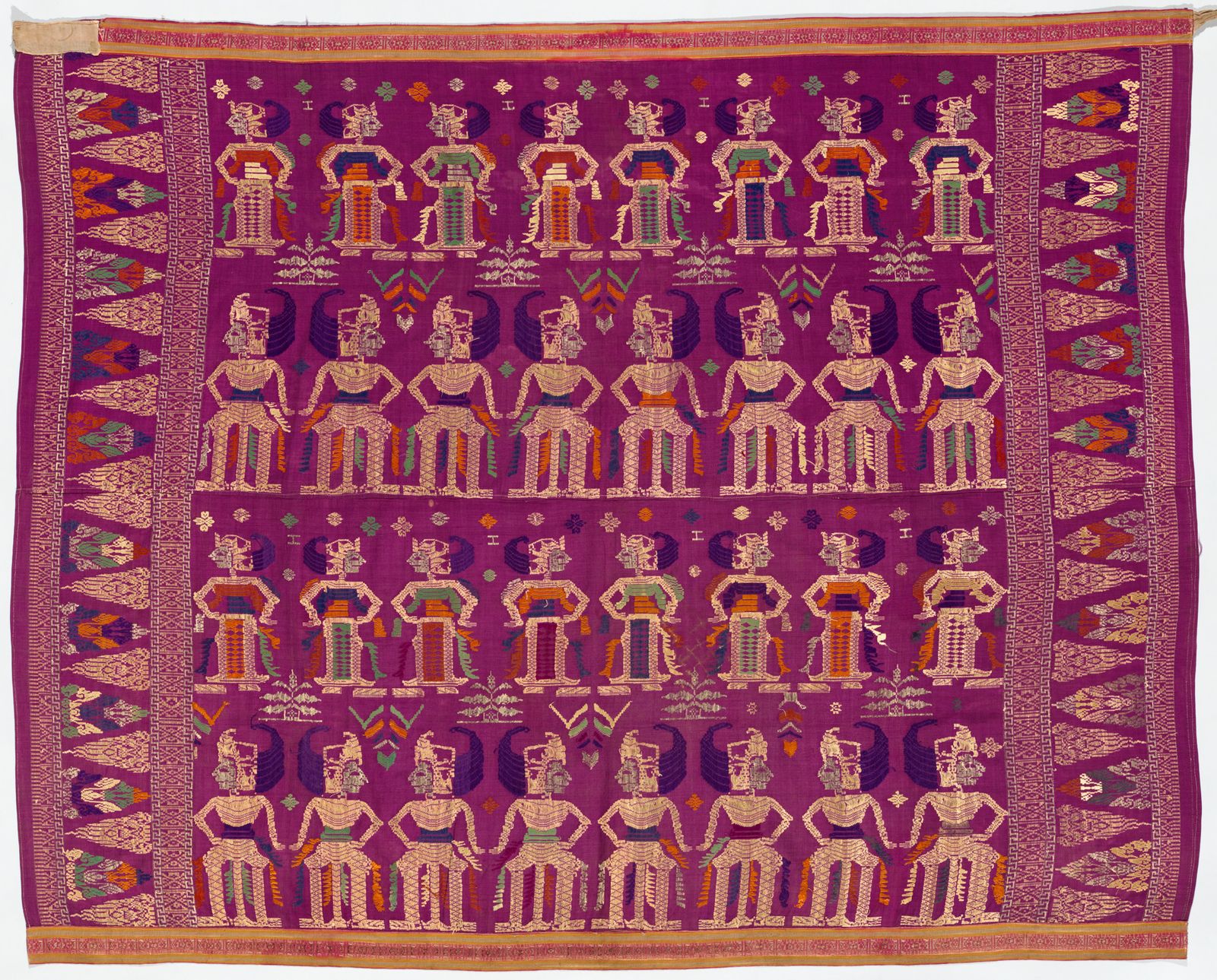 A richly coloured woven textile, in purple, orange, green and deep blue with gold thread patterened embellishments. Pictures depict dancers in traditional Balinese dress.