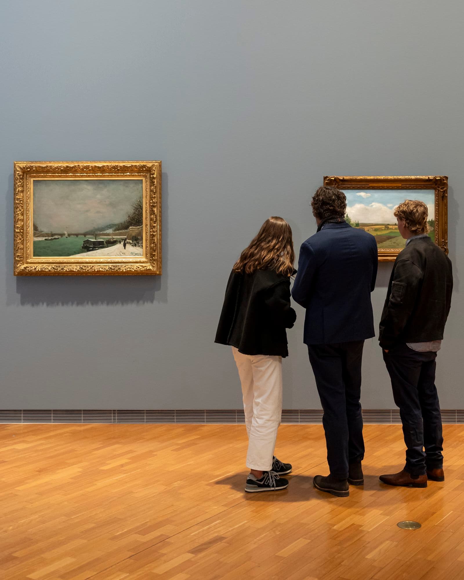 People looking at a Gauguin painting at the National Gallery of Australia