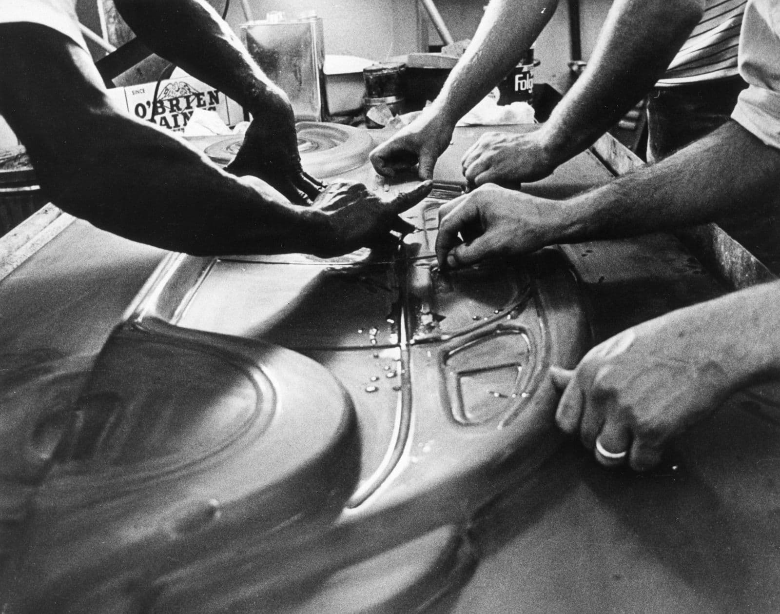 Close up of multiple hands touching and pressing a resin art mold