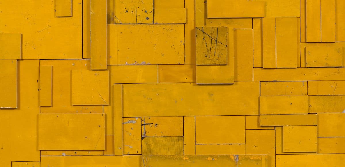 Wooden board painted yellow with squares and rectangular shapes overlayed on top