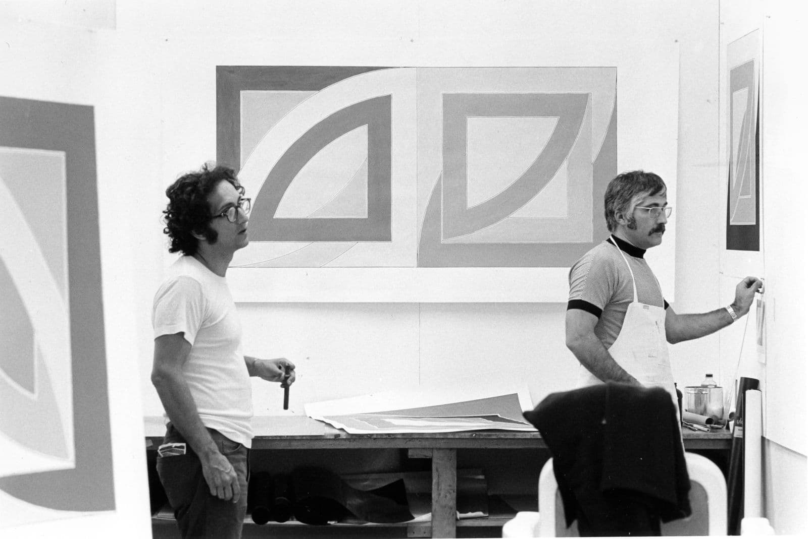 Two men looking at art work on a wall
