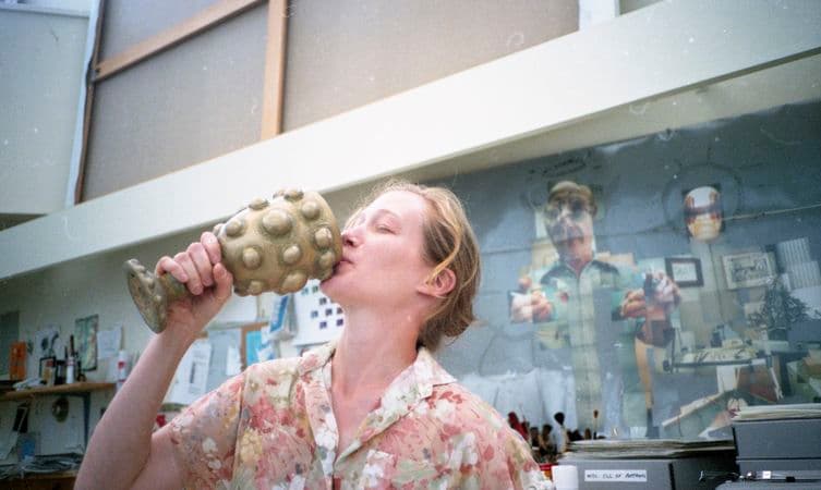 A photograph of a woman kissing a trophy