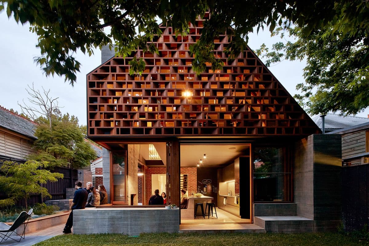 Photograph of house with interior lights and tree