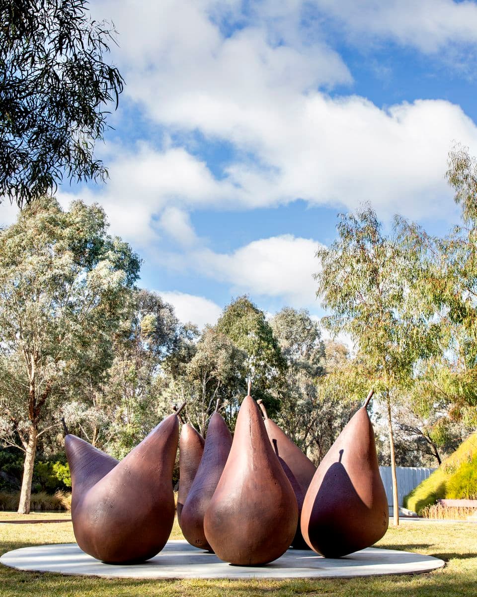 A group of seven brown metal pear sculptures