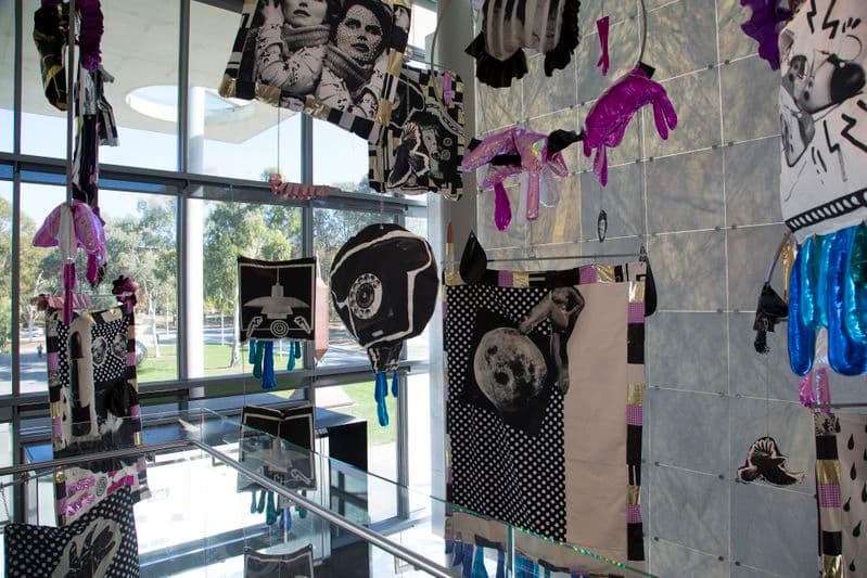 Brightly coloured objects hang from the ceiling of a largo foyer