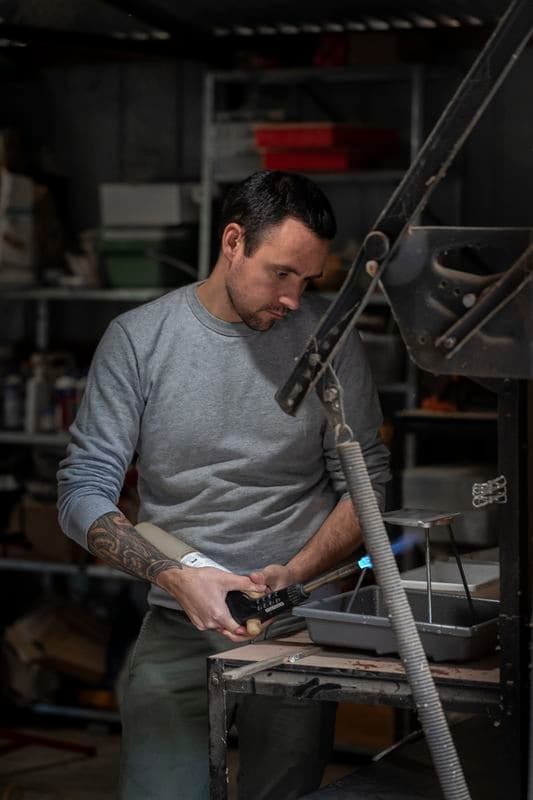 Photograph of James Tylor heating the silver plate during the gold gilding process