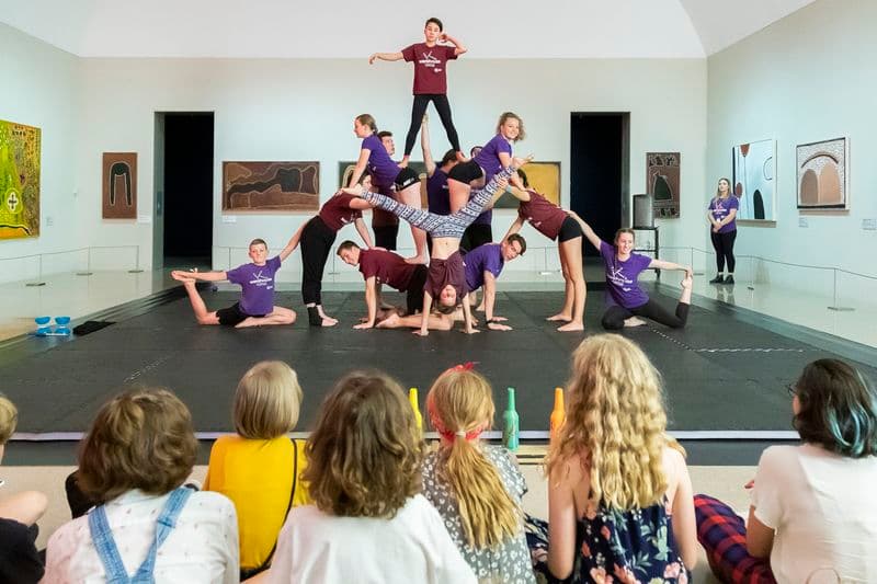 Audience of young people watching a dance troupe performing acrobatics
