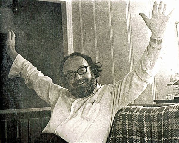 Black and white photograph of Sam Amato sitting on a couch