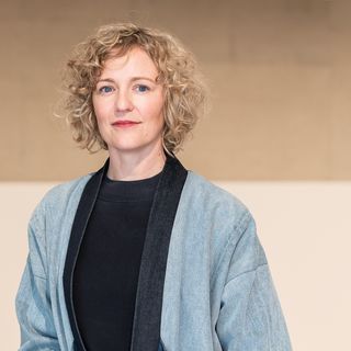 A picture of a fair skinned woman with blonde curly hair.