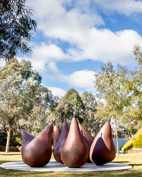 A group of seven brown metal pear sculptures